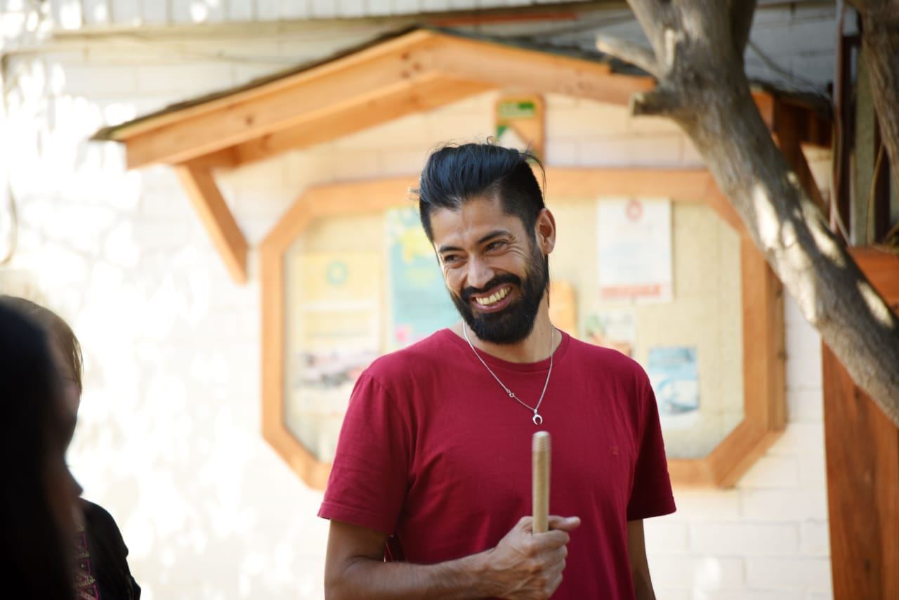 Docente sonriendo mientras sostiene una vela